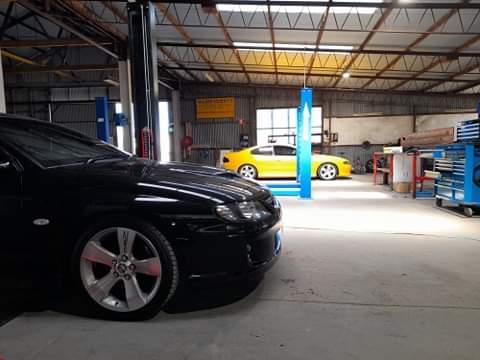 Inside the Trusted Automotive workshop, with two hoists and cars in the bays